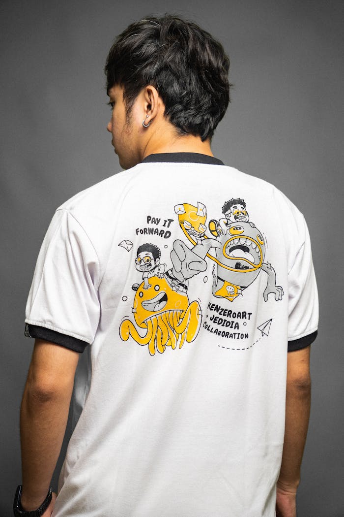 Studio shot of a man wearing a graphic t-shirt with fun cartoon characters.