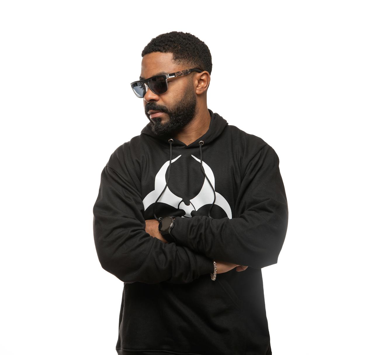 Man wearing a stylish black hoodie with a biohazard symbol, exuding confidence and style.