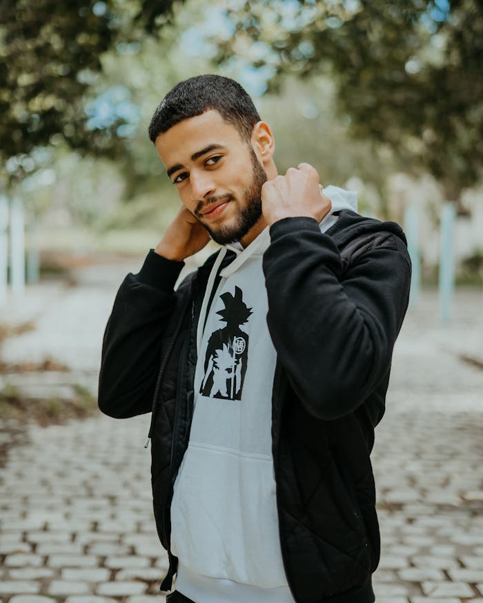 A fashionable young man poses confidently outdoors in Nabeul, Tunisia.